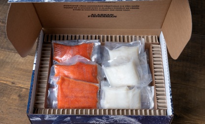 A small box of vacuum sealed portions of pacific cod and sockeye salmon